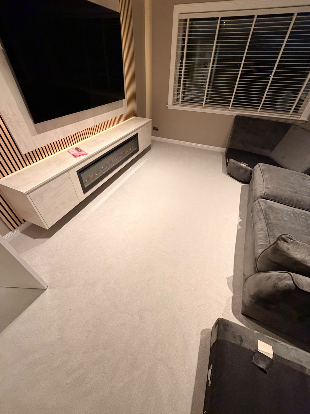 Cream carpet in a lounge with a media wall and electric fire
