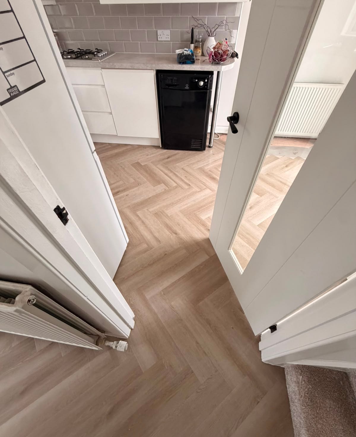 Herringbone LVT running from kitchen into hallway