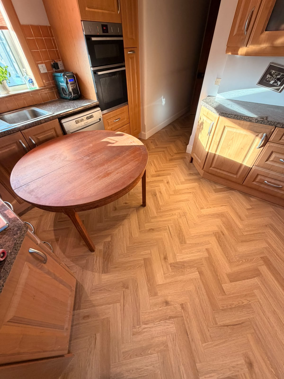 Oak parquet-effect flooring in a kitchen in warm sunlight