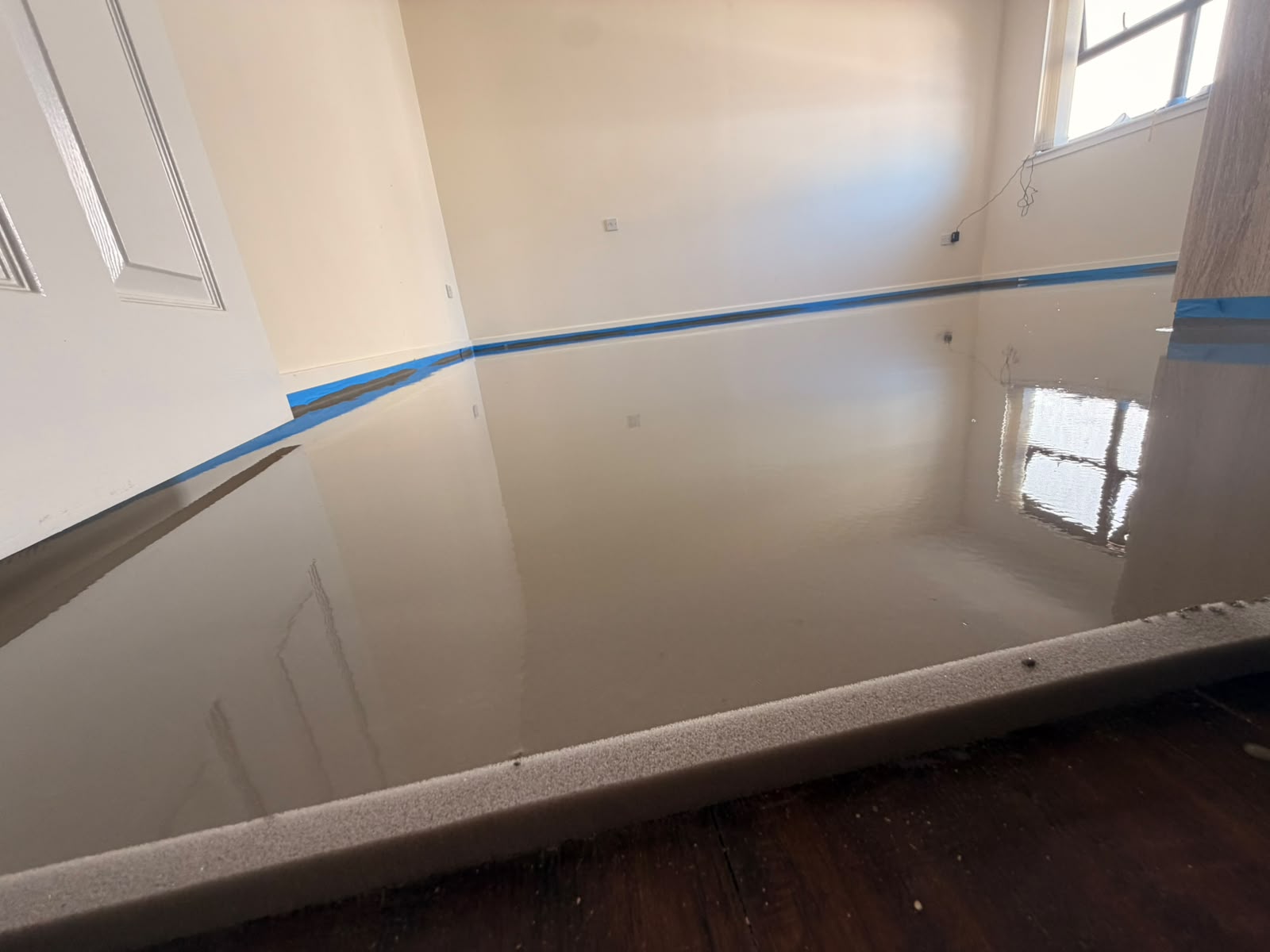 Fresh self-levelling screed poured to a glossy finish